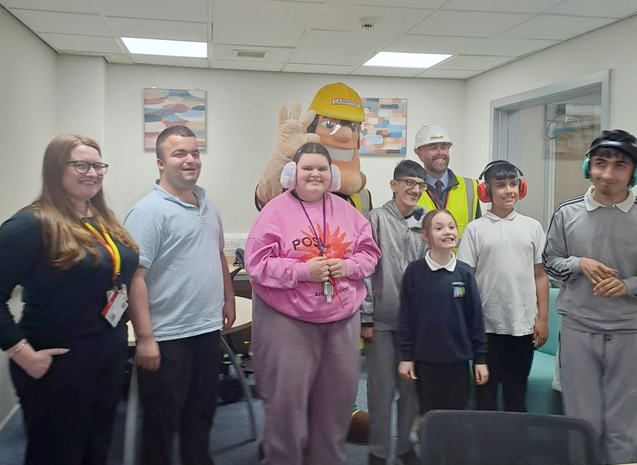 School pupils pose with mascot and staff