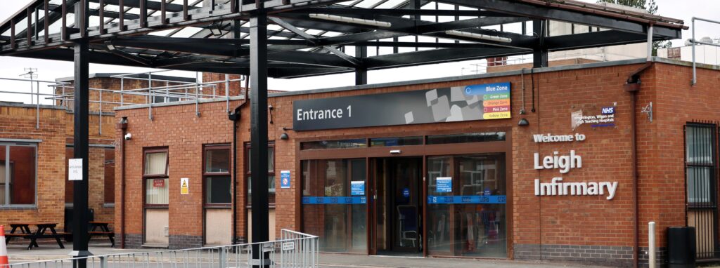 Entrance to Leigh Infirmary under a metal frame and glass roof canopy