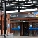 Entrance to Leigh Infirmary under a metal frame and glass roof canopy